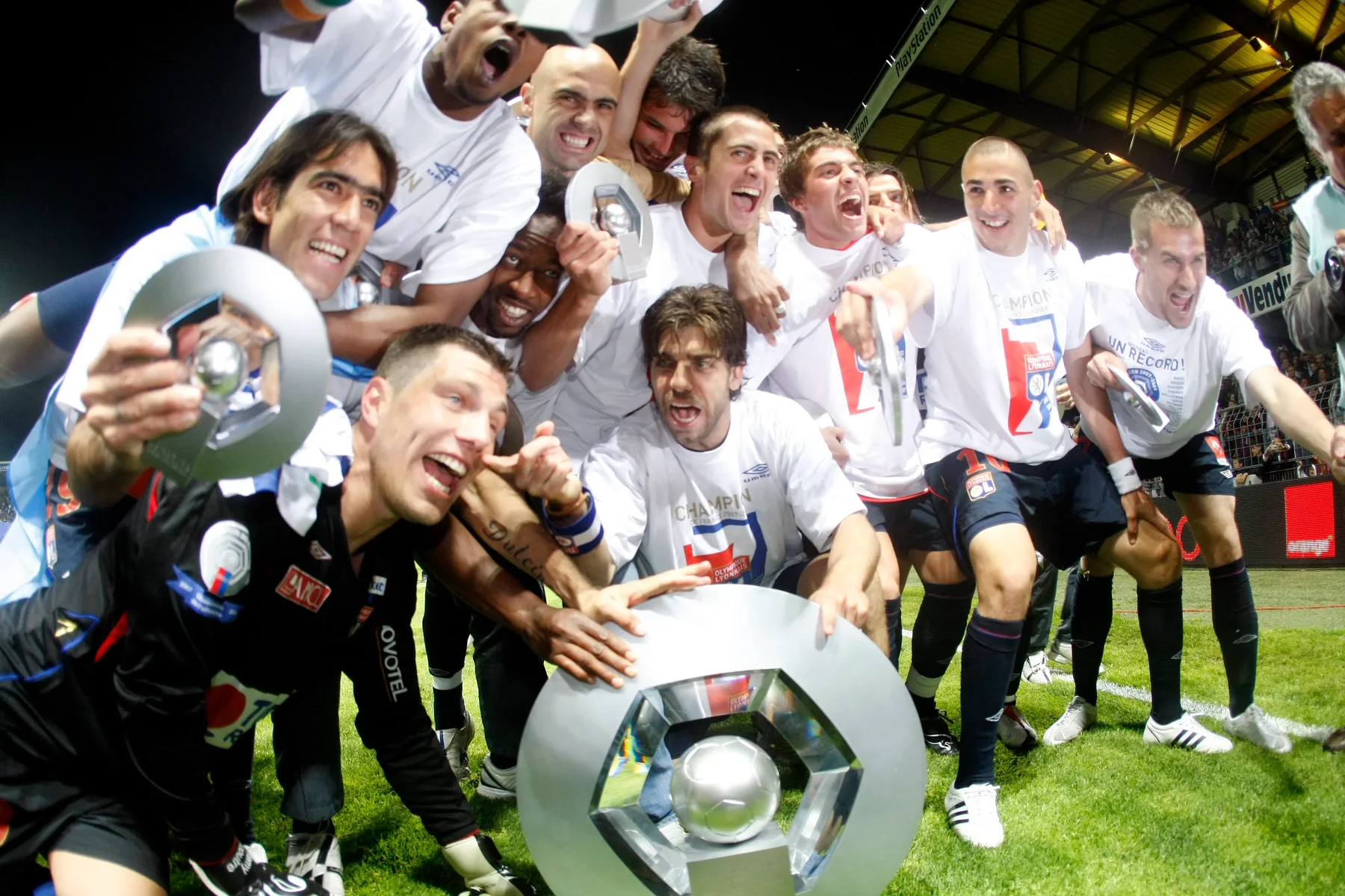 Olympique Lyonnais players celebrate with a French league trophy during their seven-title era