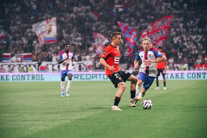 A Rennes player in red contests the ball with a Lyon player during their 19 September 2026 match